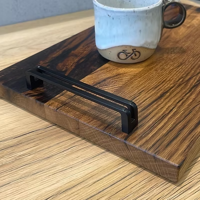 Detail von Eichenmaserung, Verguss und schwarzem Griff des Tabletts