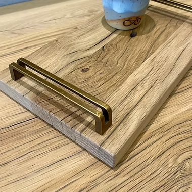Detail von Holzmaserung, Kante und Messinggriff des kleinen Tabletts